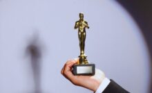 persona che tiene in mano il Premio Oscar